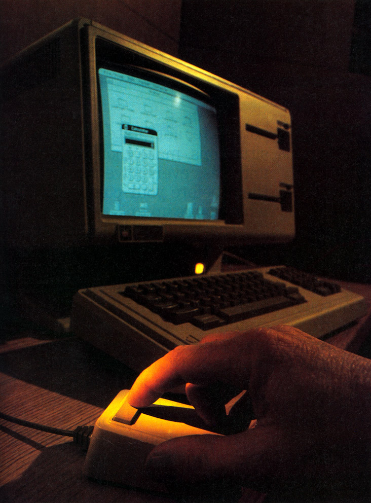 Lisa’s mouse, foreground, takes a lot of the complexity out of operating the computer. The keyboard is used for entering text and numbers into the machine. The mouse gives the commands.